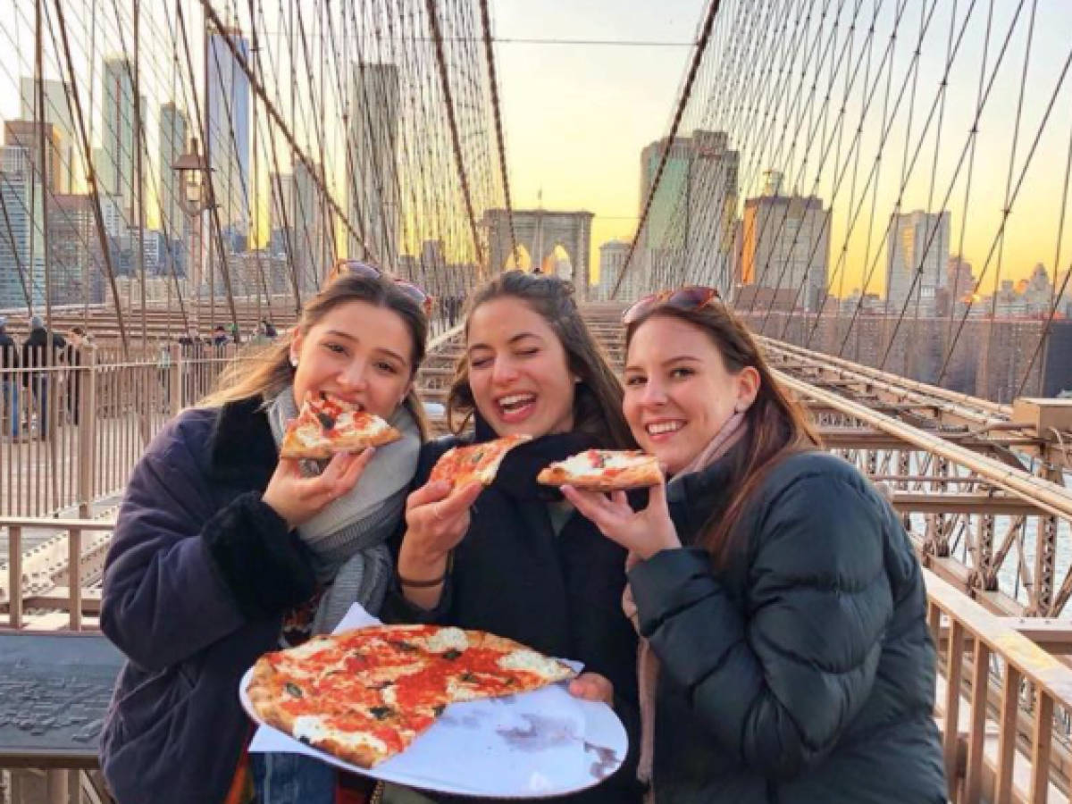 three women eating pizza