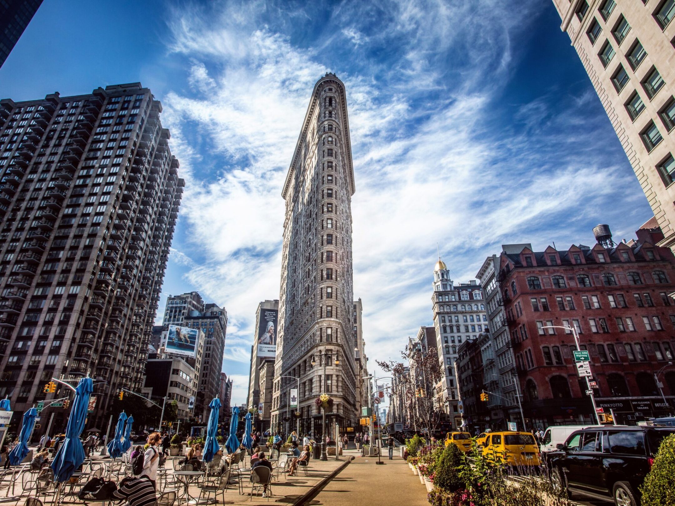 a group of people standing in front of a large city with Flatiron Building in the background