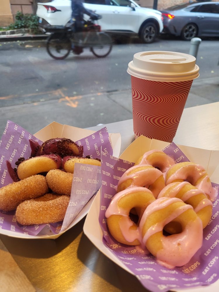 doughnuts on a table next to a cup of coffee