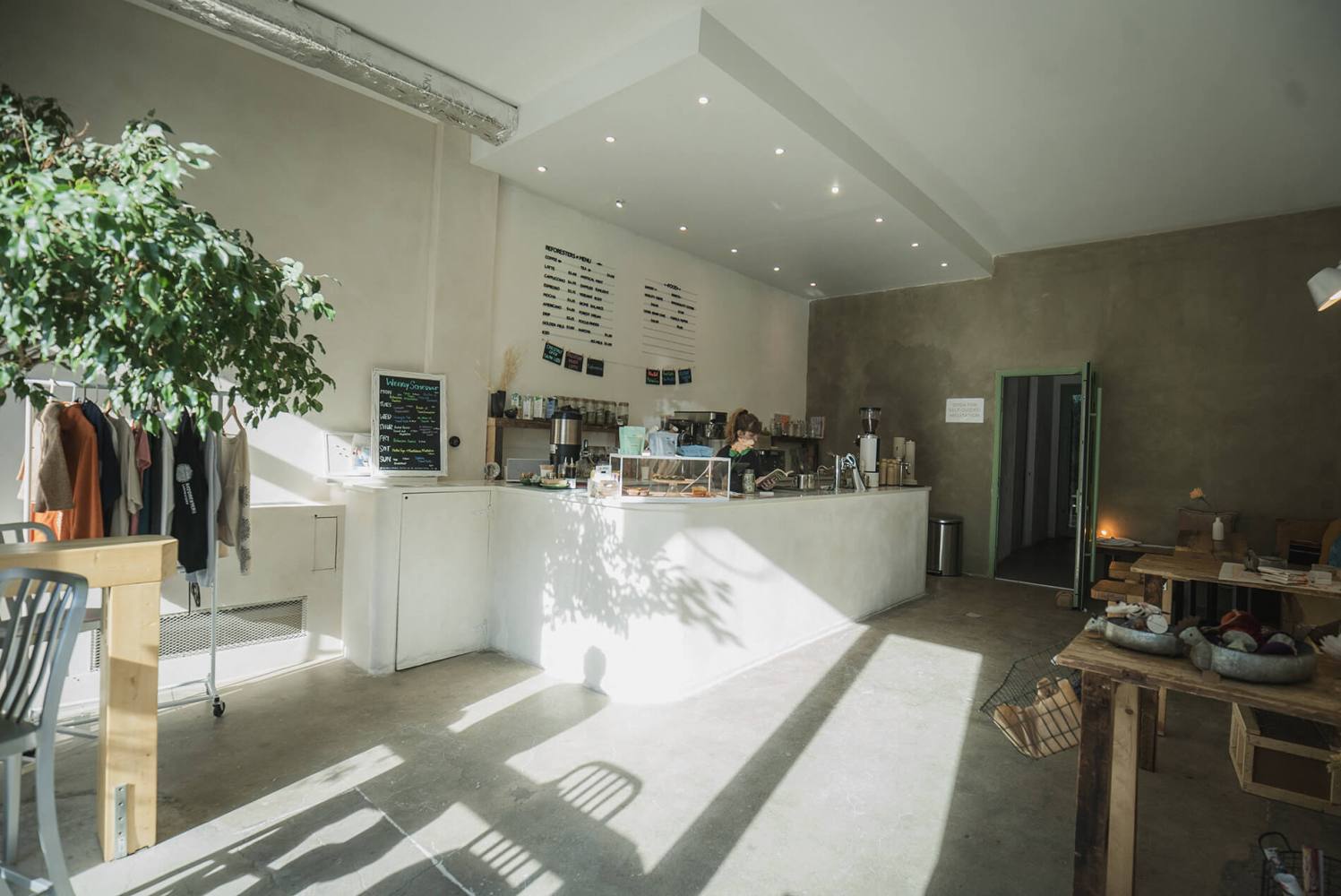a cafe room filled with furniture and a large window